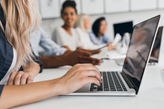 woman on laptop sitting with colleagues